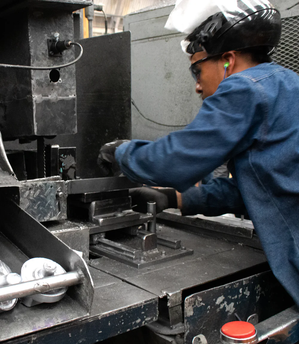 Operador trabalhando em máquina de produção dentro da fábrica